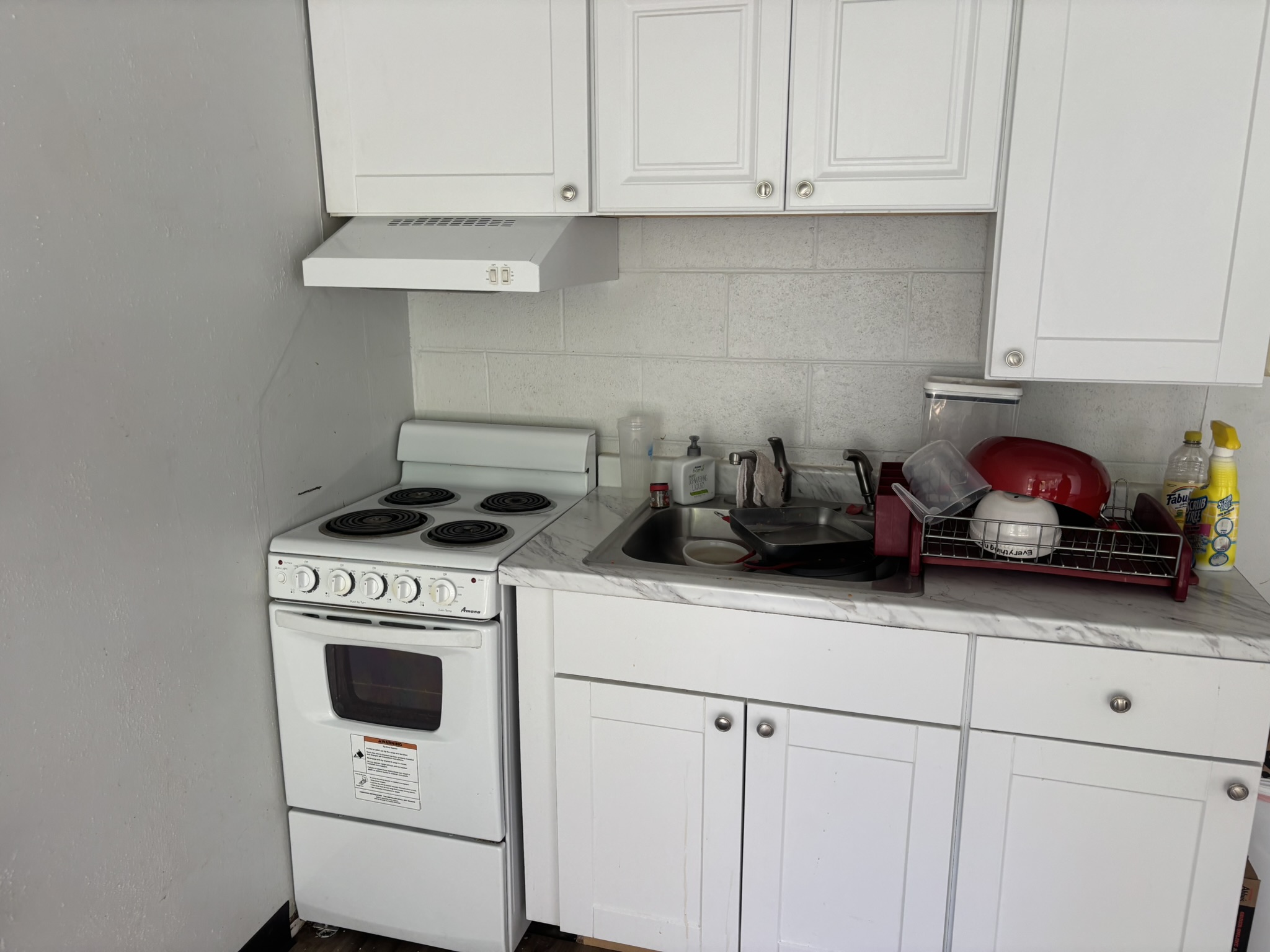 Shared kitchen with cabinets, range, and sink